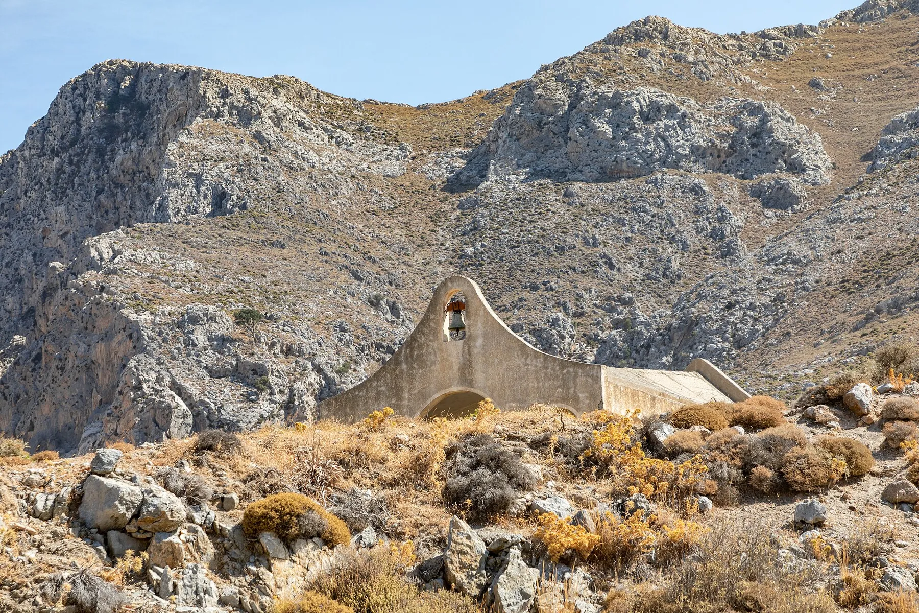 A small stone chapel below the rock cliffs near Asomatos